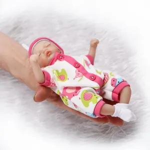 Mini reborn baby doll in pink elephant romper held in hand to show pocket size
