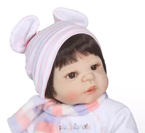 Close-up of realistic reborn doll with brown eyes, striped rabbit ear hat, and embroidery
