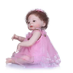 Bambola reborn realistica con capelli castani ricci e vestito in rete rosa su sfondo bianco