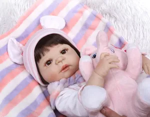 Close-up of realistic newborn baby doll face with detailed eyelashes and pink hat