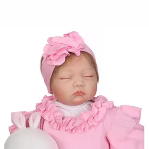 Poupée bébé réaliste endormie en tenue de dentelle rose avec bandeau et lapin jouet