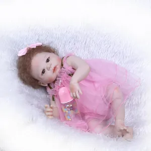 Bambola reborn realistica con capelli ricci in abito di pizzo rosa su tappeto bianco