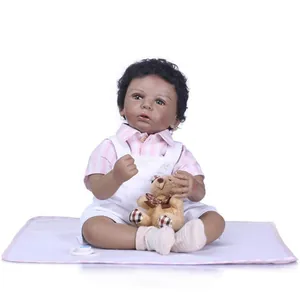 African American reborn baby doll with black curly hair in striped outfit and teddy bear