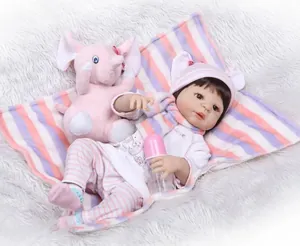 Detailed view of lifelike reborn baby doll wearing a pink knit set with plush elephant