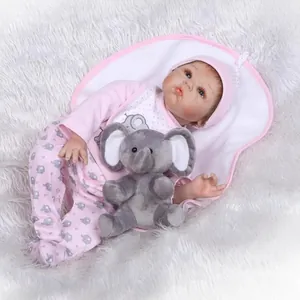 Poupée bébé reborn réaliste en tenue d'éléphant rose dormant sur un tapis en peluche blanc