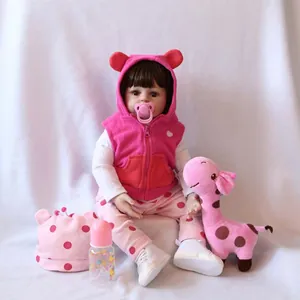 Lifelike reborn baby doll with brown hair in pink hooded vest with giraffe toy and bottle