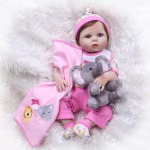 Realistic reborn baby doll in pink cartoon outfit with an elephant plush toy on fleece rug