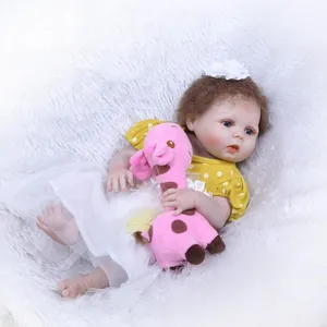 Realistic reborn baby doll in yellow polka dot dress with giraffe plush toy