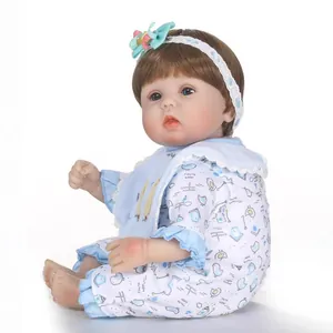 Lifelike reborn baby doll with blue eyes and brown hair in blue floral romper