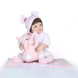 Realistic reborn baby doll in pink striped outfit holding a plush elephant toy