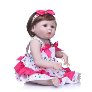 Realistic reborn baby doll with blue eyes and polka dot dress with pink bows