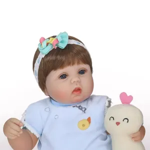 Lifelike reborn baby doll with blue eyes, brown hair and small plush bird toy
