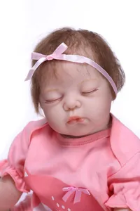 Close-up of sleeping reborn baby doll with hand-painted details and pink headband