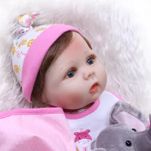 Realistic reborn baby doll with blue eyes and giraffe bib on soft white plush rug
