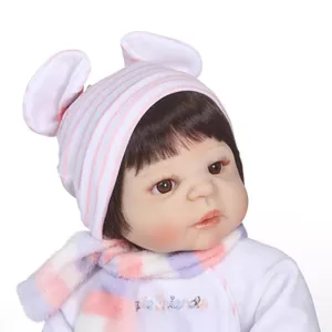 Realistic newborn reborn doll with brown hair in white bodysuit and pink striped hat