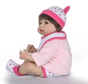Detail of reborn doll wearing a pink outfit with floral shorts and matching baby hat