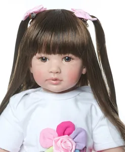 Nahaufnahme der Reborn-Puppe mit langen braunen Haaren, Zöpfen und blumigem weißen T-Shirt