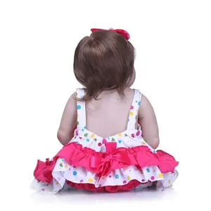 Back view of lifelike reborn baby doll with brown hair and colorful polka dot dress