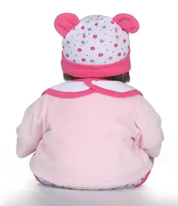 Rear view of lifelike baby doll wearing pink floral hat and soft velvet plush outfit