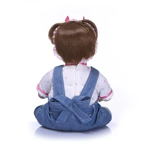Détail de la vue arrière d'une poupée reborn avec cheveux bruns et nœuds roses