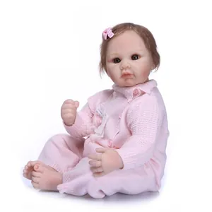 Close-up of lifelike newborn baby doll in pink knit outfit and bow headband