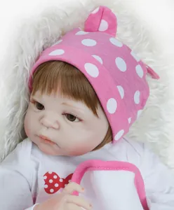 Close-up of realistic newborn doll with hand-painted eyelashes and pink polka dot hat