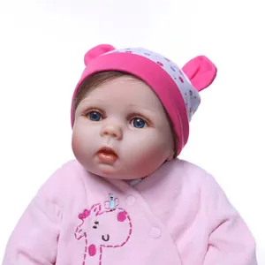 Lifelike reborn baby doll in pink plush outfit with giraffe motif and floral ear hat