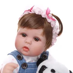 Poupée bébé reborn réaliste avec cheveux bruns, salopette en jean et peluche panda