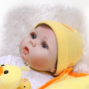 Realistic reborn baby doll with blue eyes and yellow knit hat on soft white carpet