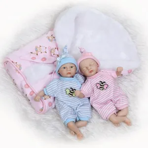 Realistische pasgeboren babypoppenset met blauwe en roze kleding op zachte deken
