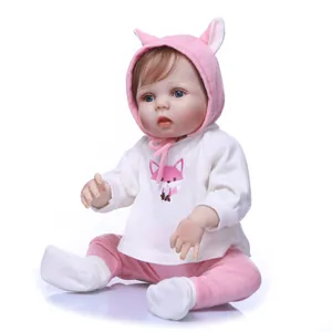 Realistic reborn baby doll in pink fox outfit with animal ears hat on white background