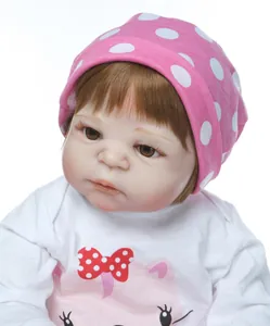 Close-up of realistic reborn doll face with brown eyes and pink cartoon cat outfit
