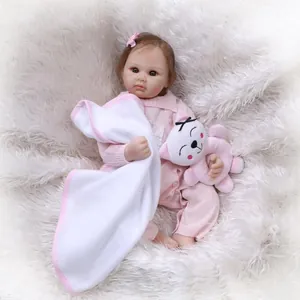 Realistic reborn baby doll in pink knit romper with plush toy on soft white rug