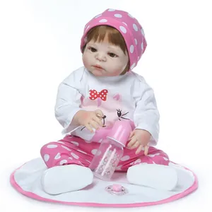 Detail of reborn baby doll outfit featuring cat pattern t-shirt and pink polka dot hat
