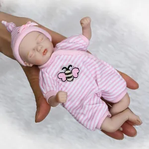 Mini reborn babypop in roze gestreepte outfit slaapt vredig in de hand