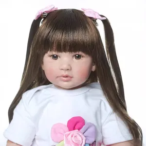 Reborn Kleinkind-Puppe mit braunem Haar, rosa Schleifen und floralem T-Shirt auf Weiß