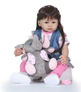 Bambola realistica reborn con capelli castani, gilet blu e peluche a forma di elefante