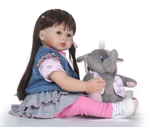 Dettaglio della bambola reborn con capelli castani e peluche di elefante coordinato