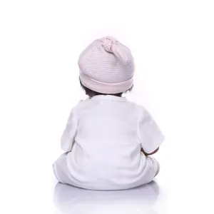 Close-up of white baby bodysuit and striped knot hat on a soft cotton doll outfit