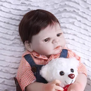 Poupée bébé reborn réaliste avec cheveux bruns, salopette en jean et petit ours en peluche