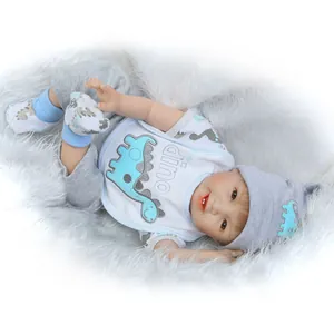 Dettaglio di una bambola reborn realistica con abito da dinosauro su tappeto di peluche