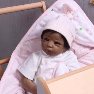Lifelike African reborn baby doll with pink striped hat and star pattern swaddle blanket
