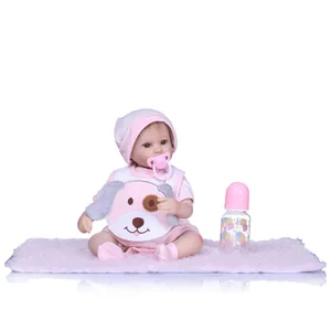 Realistic reborn baby doll in pink striped outfit with pacifier and nursing bottle