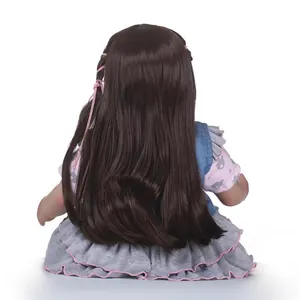 Bambola Reborn realistica con lunghi capelli castani e gilet di jeans su abito grigio