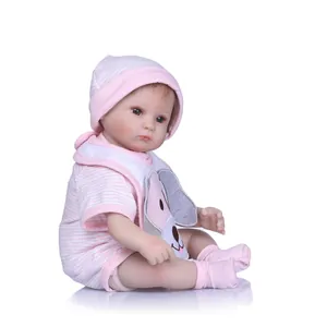 Realistic reborn baby doll in pink striped outfit with dog bib and matching hat