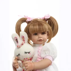 Realistic silicone newborn doll with blonde pigtails in lace dress holding a bunny toy