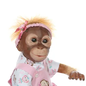 Lifelike baby orangutan reborn doll with orange hair and pink dress on white background