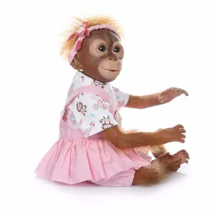 Detailed view of lifelike baby monkey doll with orange fur and pink dress