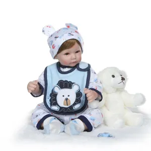 Realistic reborn baby boy doll in blue cartoon outfit with plush bear and pacifier