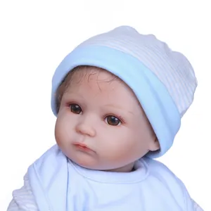 Close-up of lifelike baby doll featuring detailed facial expressions and a striped hat